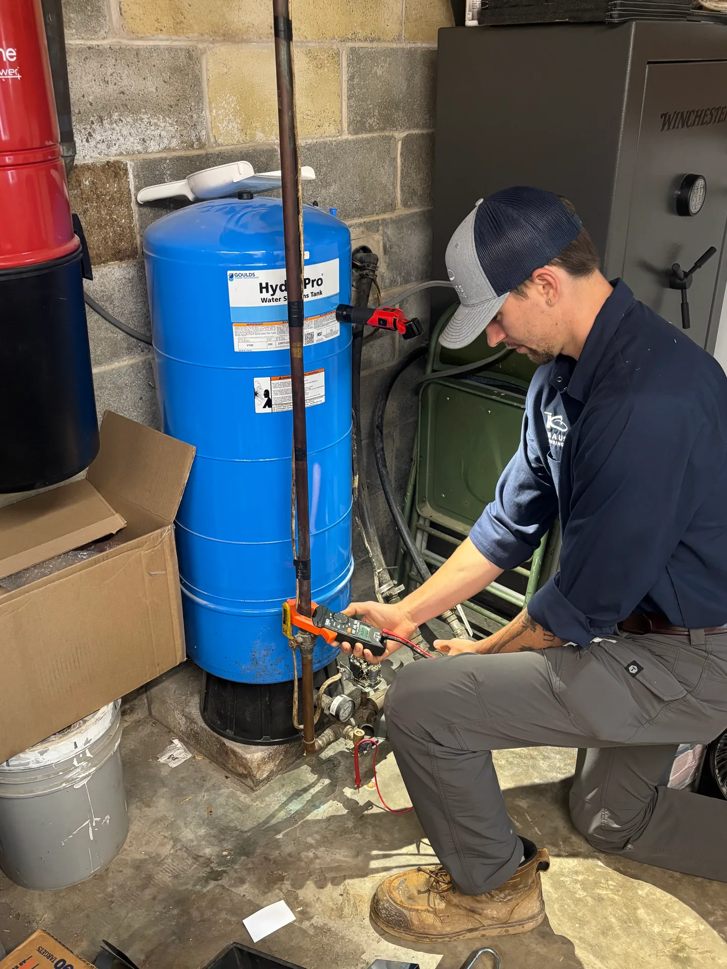 Pressure Tank Service by Knauss Plumbing Knauss Plumbing owner servicing a blue pressure tank in a home utility room.
